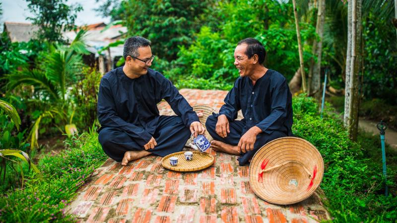 A tourist respectfully interacting with a local Vietnamese person in Hue.